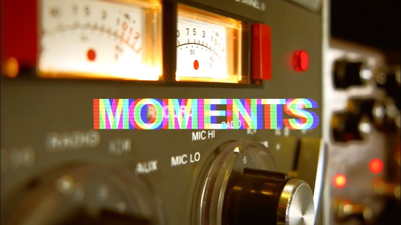 Videostill aus «Moments»: analoge Bandmaschine mit glühenden VU-Metern und rotem Signallicht.